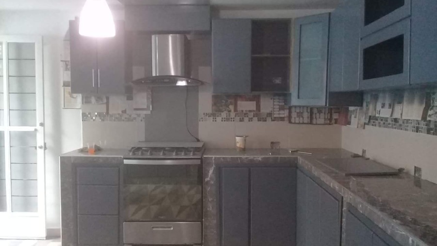 Cocina con encimera de concreto y puertas de madera