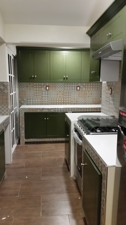 Cocina de concreto forrada de loseta con puertas de madera