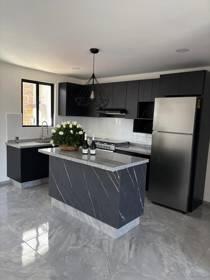 Cocina contemporánea con isla protagonista y diseño sobrio