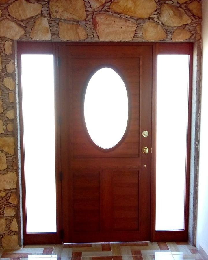 Puerta batiente, en aluminio imitación madera.