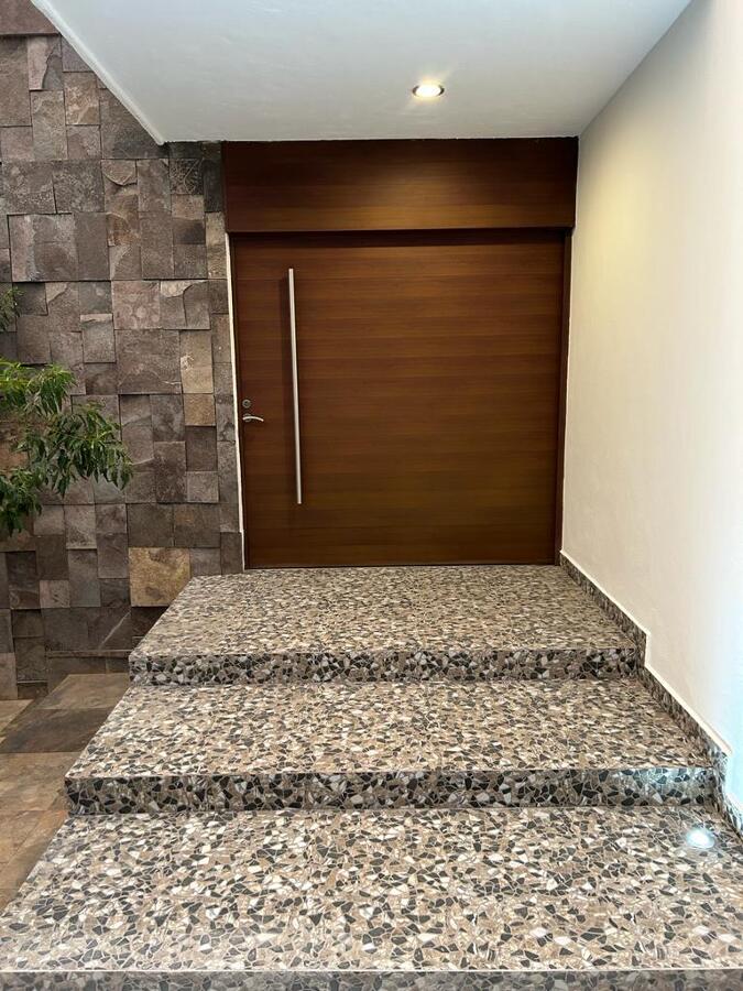 Acceso principal con materiales naturales