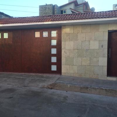 Fachada exterior Con portón pintado, Muro con acabado y Techumbre con teja