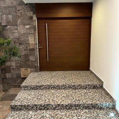 Acceso principal con materiales naturales