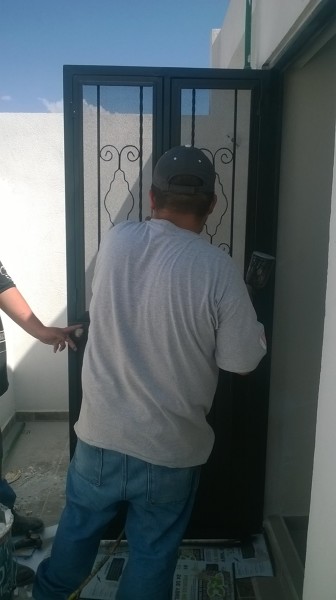 Puerta de servicio con mosquiteros y ventanas abatibles