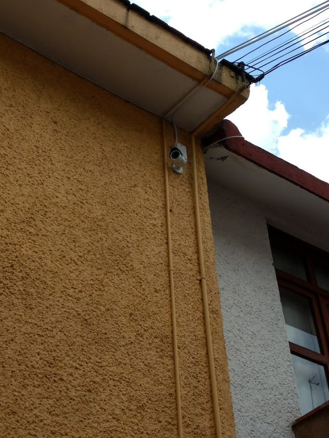 Cámara viendo el pasillo de condominio ,con la visión  "encontrada" con la otra