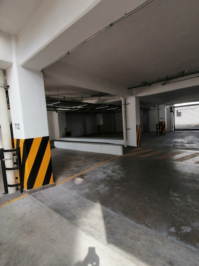 Jardineras vacias bajo techo en estacionamiento residencial