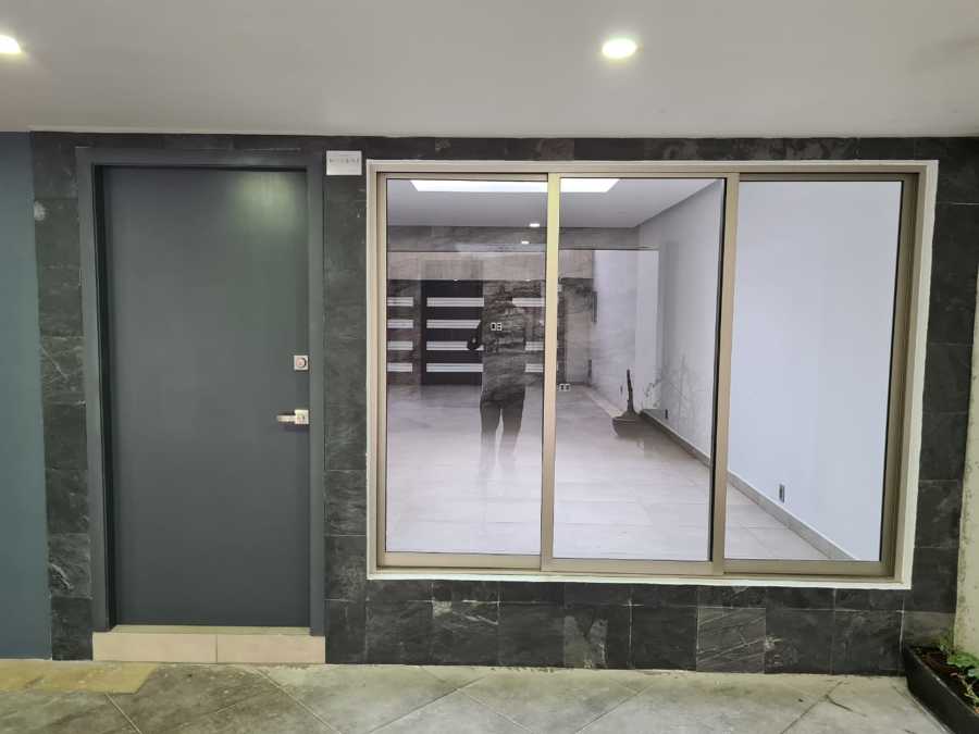 Ventanal aluminio línea española. Puerta de madera acabado en tono gris mate.